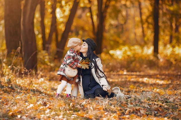 Familia linda y elegante en un parque de otoño