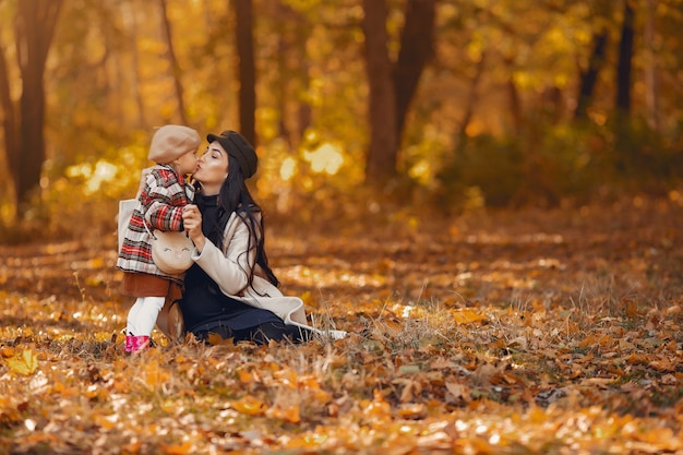 Familia linda y elegante en un parque de otoño