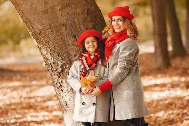 Familia linda y elegante en un parque de otoño