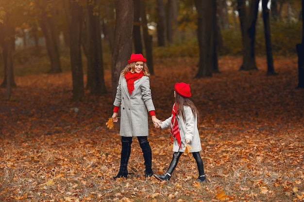 Familia linda y elegante en un parque de otoño