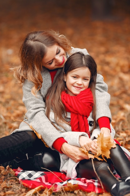 Familia linda y elegante en un parque de otoño