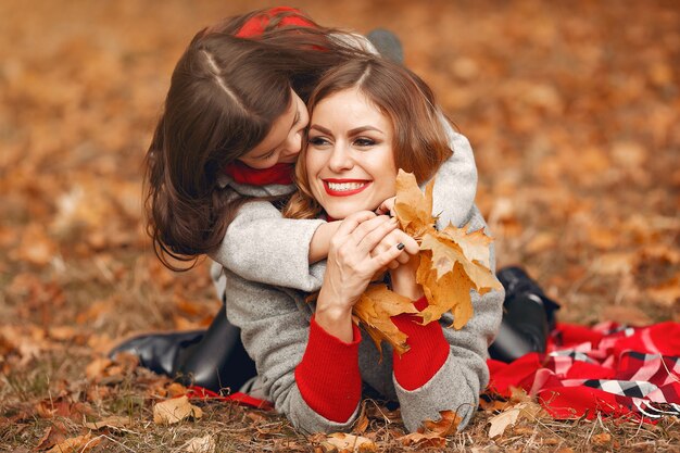 Familia linda y elegante en un parque de otoño