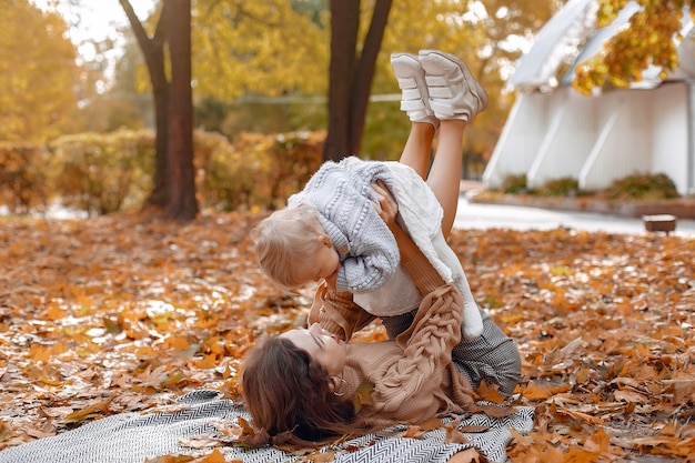 Familia linda y elegante en un parque de otoño