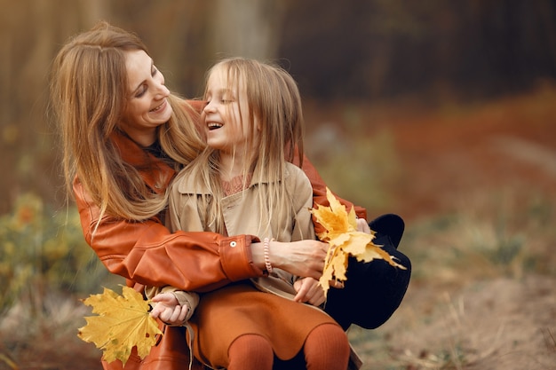 Familia linda y elegante en un parque de otoño