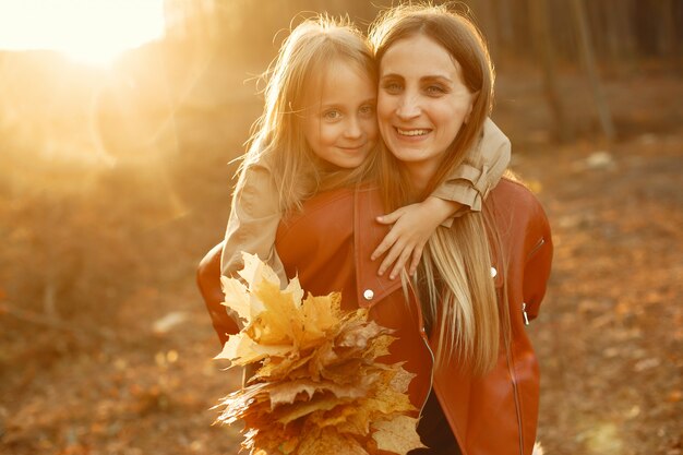 Familia linda y elegante en un parque de otoño