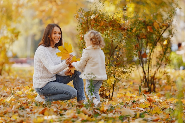 Familia linda y elegante en un parque de otoño