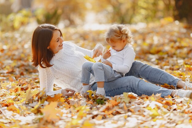 Familia linda y elegante en un parque de otoño