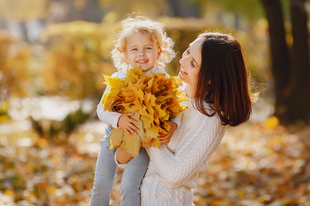 Familia linda y elegante en un parque de otoño