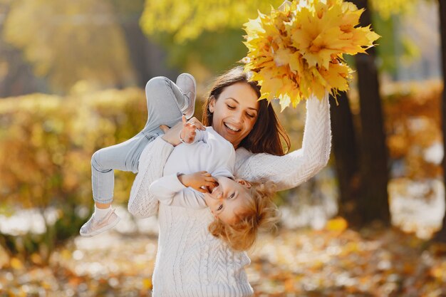 Familia linda y elegante en un parque de otoño