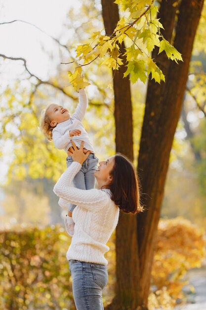 Familia linda y elegante en un parque de otoño