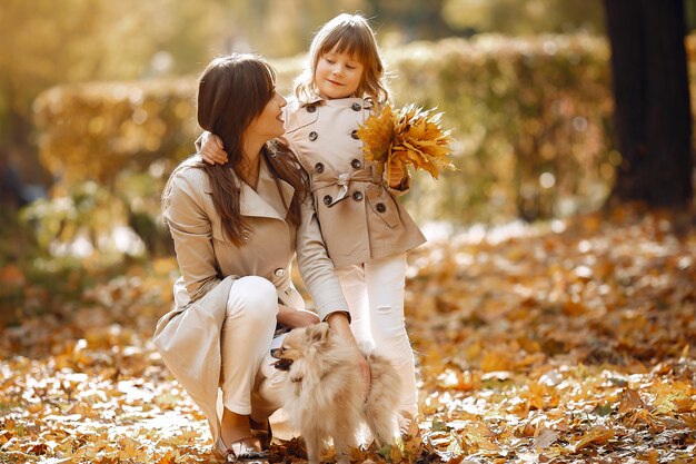 Familia linda y elegante en un parque de otoño