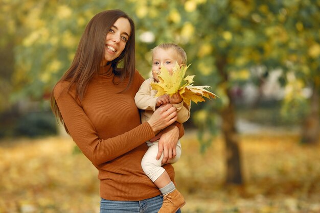 Familia linda y elegante en un parque de otoño