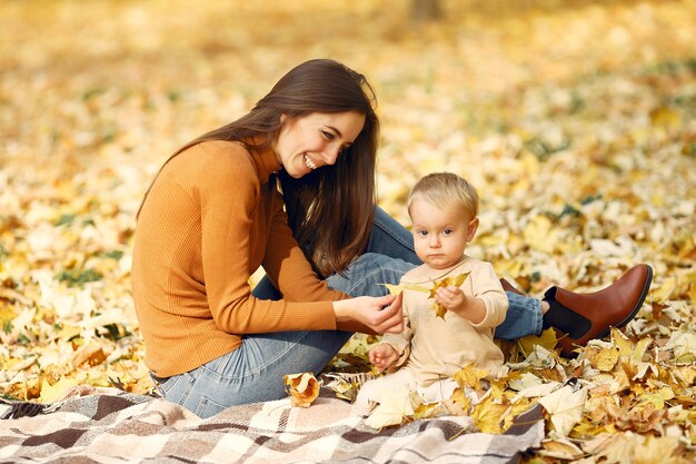 Familia linda y elegante en un parque de otoño