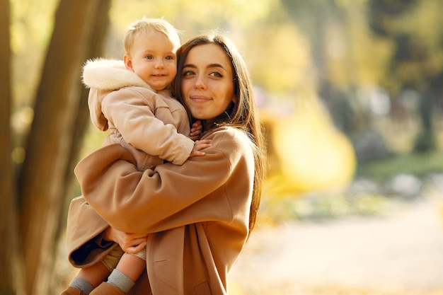 Familia linda y elegante en un parque de otoño