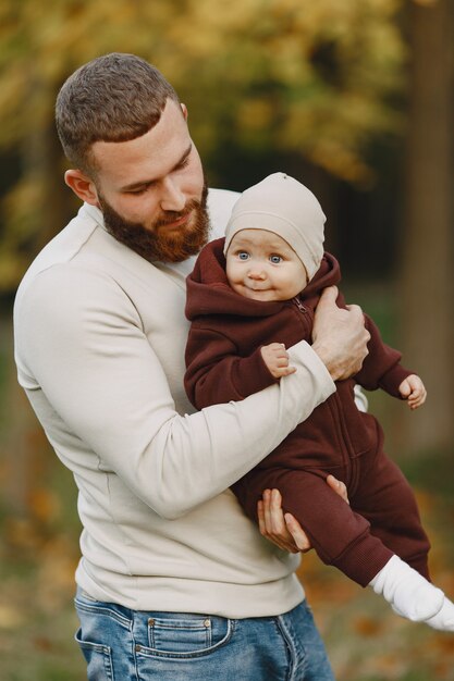 Familia con linda hija. Padre con un suéter marrón. Niña con papá.