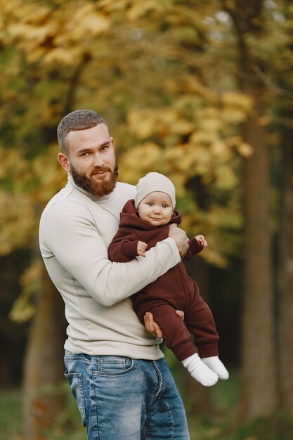 Familia con linda hija. Padre con un suéter marrón. Niña con papá.