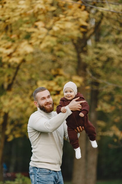 Familia con linda hija. Padre con un suéter marrón. Niña con papá.