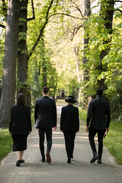 Familia de luto vestida de negro visitando el cementerio