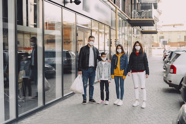 Familia en máscaras protectoras con compras