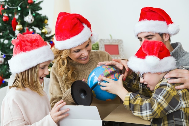 Familia mirando como niño abre un regalo