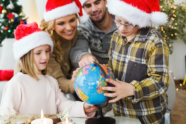 Familia mirando como niño mira su globo de la tierra