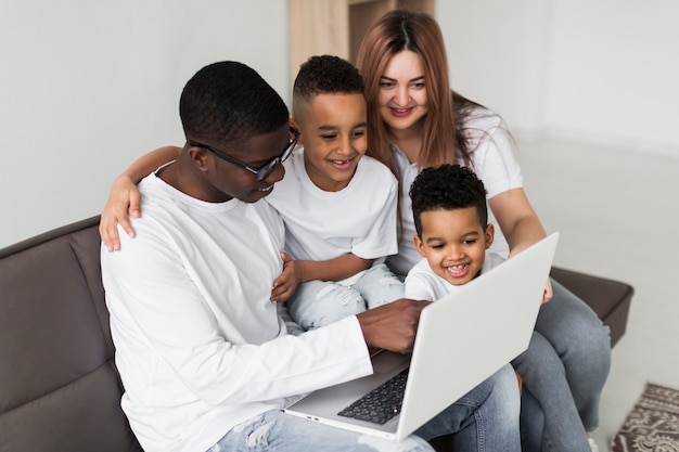 Familia mirando juntos en una computadora portátil