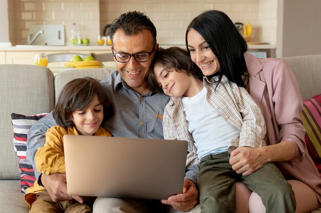 Familia mirando juntos en un portátil en casa