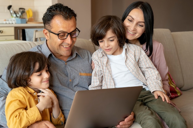 Familia mirando juntos en un portátil en casa