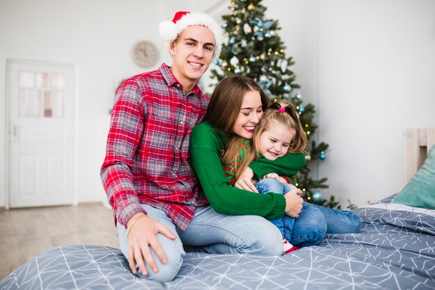 Familia moderna en la cama en navidad