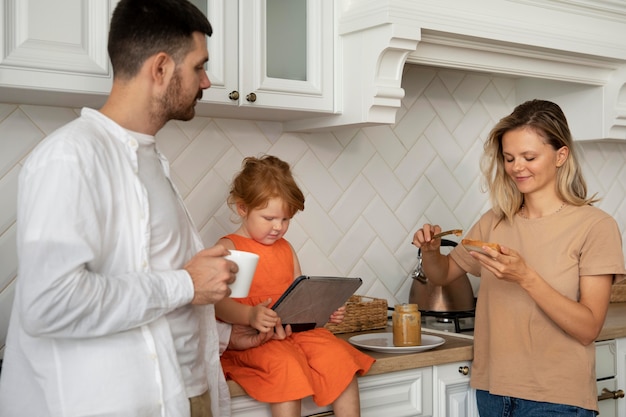 Foto gratuita familia moderna con tableta de tiro medio