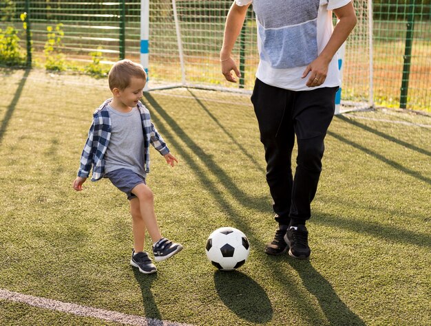 Familia monoparental feliz jugando al fútbol