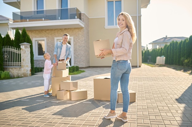 Familia mudarse a una nueva casa y llevar cajas de cartón.