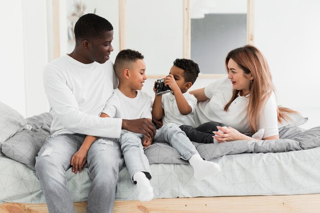 Familia multicultural jugando con una cámara en interiores