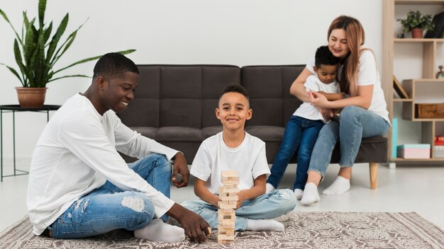 Familia multicultural jugando un juego de torres de madera