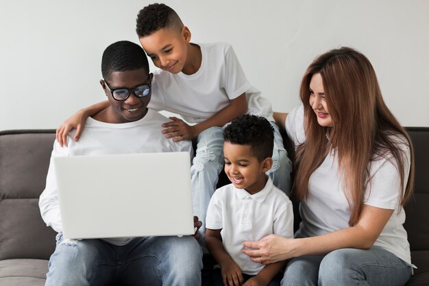 Familia multicultural mirando en una computadora portátil