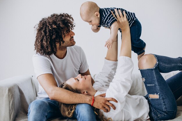 Familia multicultural con su pequeño hijo divirtiéndose juntos