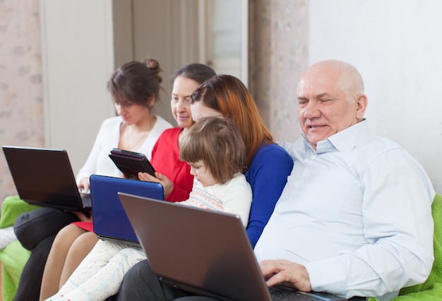Familia multigeneraciones con dispositivos electrónicos