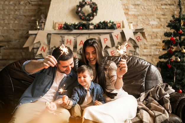 Foto gratuita familia en navidad con luces de bengala