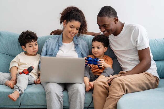 Familia negra feliz mirando algo en la computadora portátil y riendo