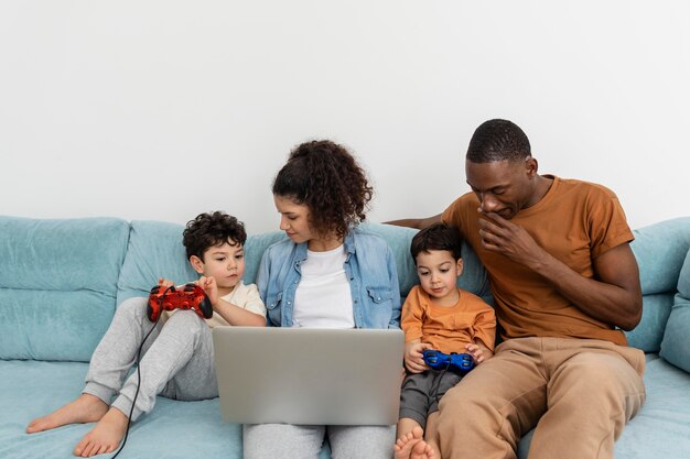 Familia negra feliz viendo un espectáculo en la computadora portátil