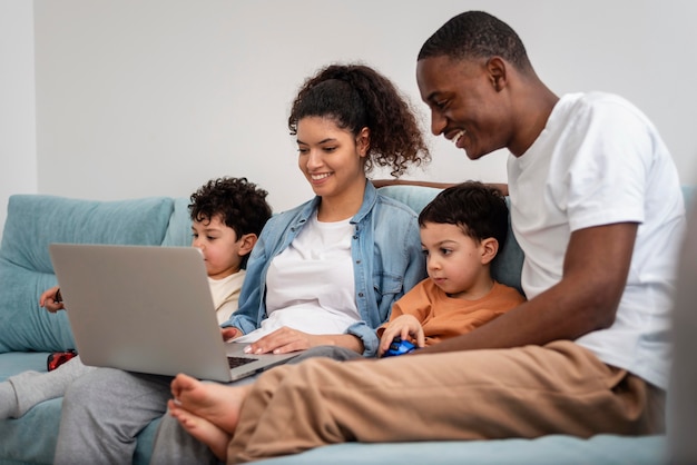 Familia negra feliz viendo una película en la computadora portátil