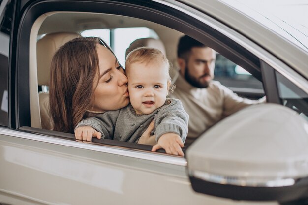 Familia con niña bbay eligiendo un coche en una berlina.