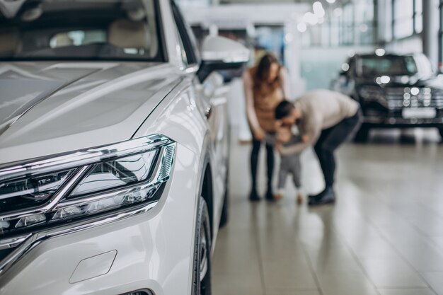 Familia con niña eligiendo un coche en un salón de autos