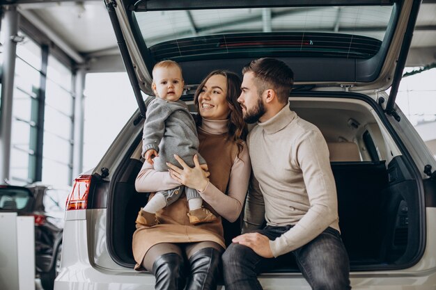Familia con niña pequeña eligiendo un coche en una sala de exposición de coches