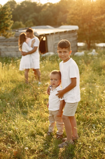 Foto gratuita familia con niño lindo. padre con camiseta blanca. fondo del atardecer.