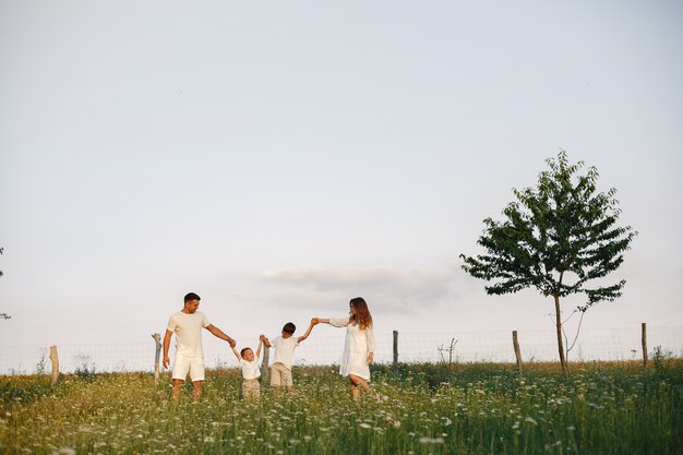 Familia con niño lindo. Padre con camiseta blanca. Fondo del atardecer.