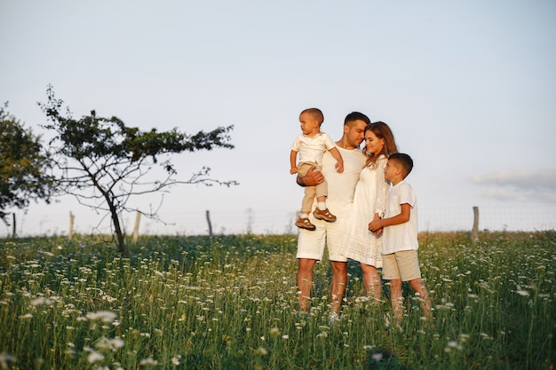 Familia con niño lindo. Padre con camiseta blanca. Fondo del atardecer.