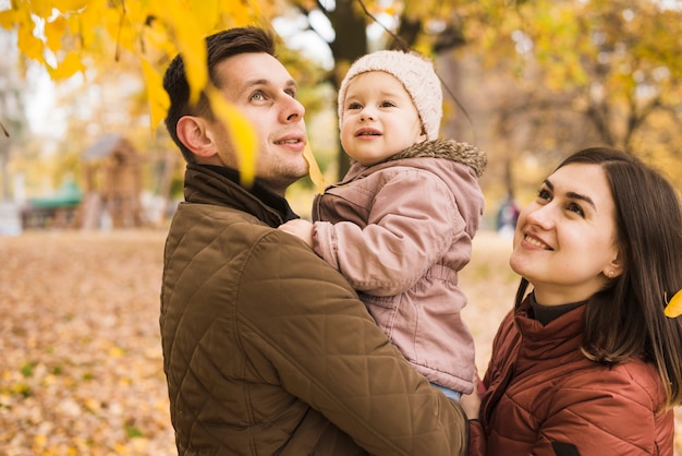 Foto gratuita familia en el parque admirando de la naturaleza de otoño