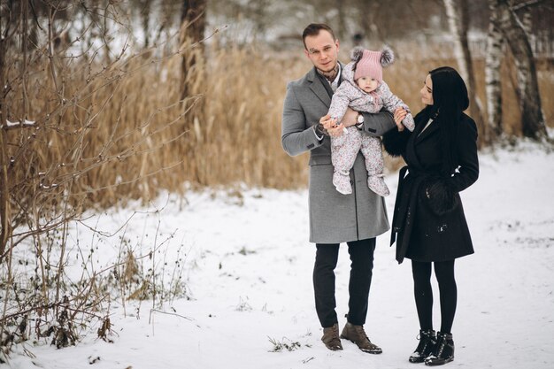 Familia en el parque en invierno con bebé hija