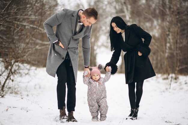 Familia en el parque en invierno con bebé hija